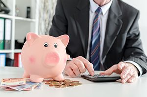 Banker counting money with piggy bank