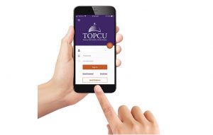 Hands holding cell phone with finger pointing to TOPCU mobile app display